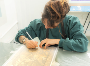 Stagiaire travaillant la pose de feuille d'or